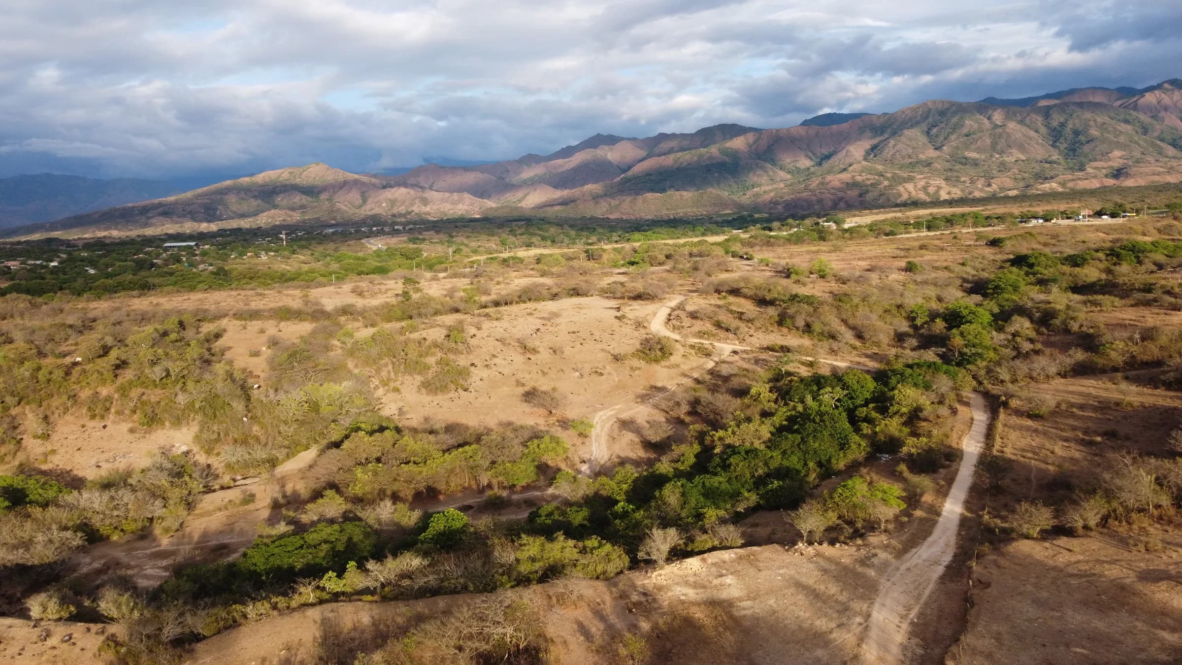 Vista aérea del predio Finca Los Cristales y las montañas del valle del Huila, con caminos de tierra recorriendo el terreno.